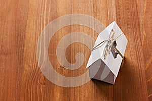 Model of cardboard house with a bow of twine and key.