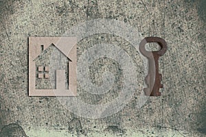 model of cardboard house with key on old textured paper background