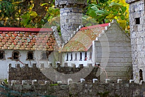 a model of a castle with a red roof and a red roof top and a white house with a red roof, a tilt shift photo