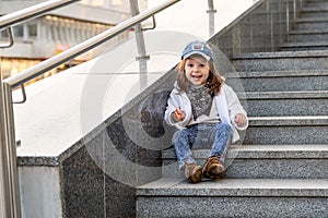 Model child hip-hop sitting on stairs outdoor