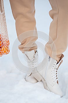 The model demonstrates women`s shoes standing in the snow