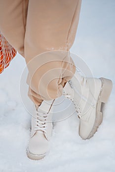 The model demonstrates women`s shoes standing in the snow