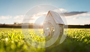 Model detatched cottage house in empty field at sunset background concept for construction and real estate