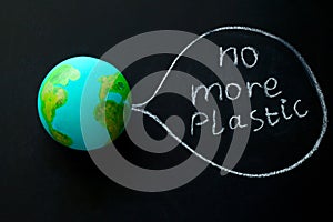 model of the Earth planet on a chalkboard with the inscription no more plastic,environmental concept