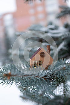 A model of an eco-friendly wooden house on a winter background.