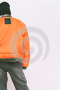 Model in fashion urban street outfit. Trendy orange bomber jacket and stylish black denim. Fall winter seasons lookbook
