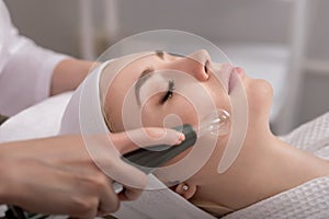Model geting cleansing peeling rejuvenating facial treatment in a beauty SPA salon photo