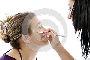 Model getting eye makeup from beautician