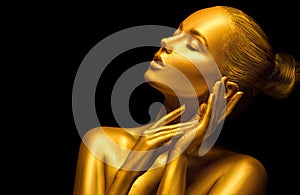 Model girl with shiny golden professional makeup over black. Beauty sexy woman with golden skin. Fashion art portrait closeup