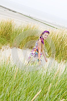 Model girl walking in sand dunes beach