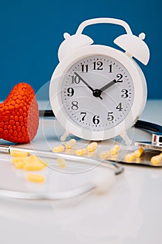 Model of gland and alarm clock with medicines. Health check up and disease prevention concept. Vertical image