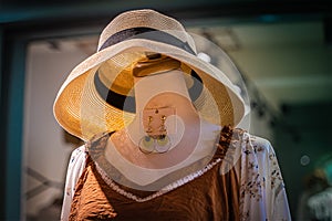 A model without head wearing new dress and a hat at a dress store in Tainan street