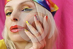 A model in a headscarf with a multicolored manicure