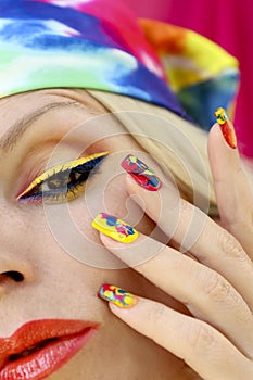 A model in a headscarf with a multicolored manicure