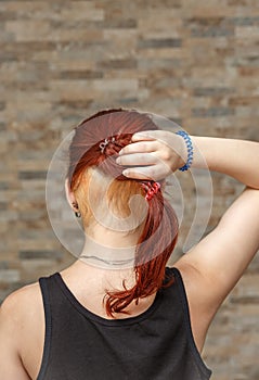 Model holding colored tail with hidden undercut