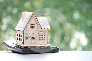 Model house on calculator on natural green background,Business investment and Property tax concept