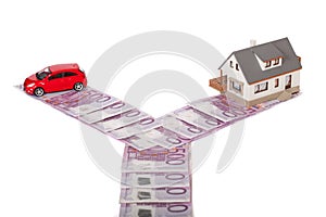 Model house, car and five hundred euro banknote crossroad