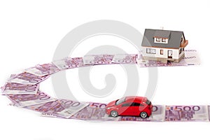 Model house, car and five hundred euro banknote road