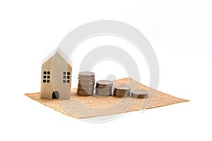 Model house and coin stack on white background mortgage