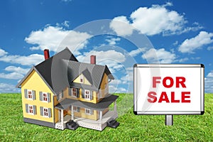 Model house on green grass with for sale sign