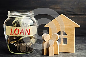 Model of the house, money and the inscription `Loan`. Buying a home in debt. Family investment in real estate and risk management