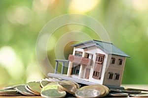 A model house model is placed on a pile of coins.using as background business concept and real estate concept with copy space for photo