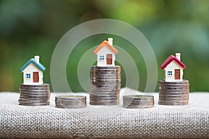 Model house on stack of coins. Saving money for home purchase, mortgage and real estate investment