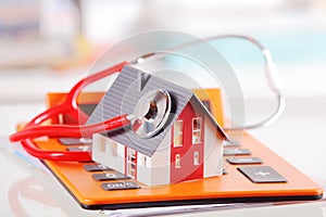 Model House with Stethoscope on Calculator Device