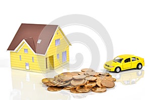 Model house and toy car with coins