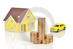 Model house and toy car with coins