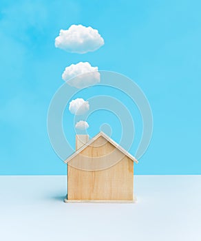 Model of Househome made by wood with cloud from smokestack on pastel color background.Property and estate or  environment,