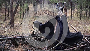 Model in an image of Maleficent throws a black cloak