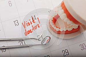 Model of jaw on calendar with mark close-up. Dental care concept