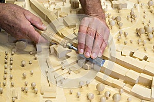 Model maker at work with chisel