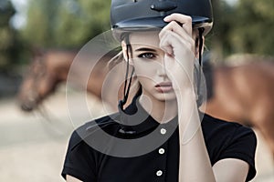 Model with perfect makeup holds a helmet with one hand