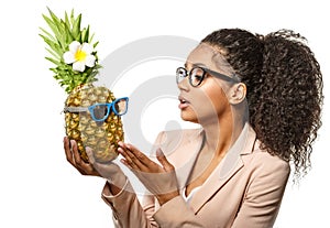 Model with pineapple in hands. African American Girl with Exotic Fruit. Cheerful woman with a smile relaxing on vacation. Image