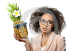 Model with pineapple in hands. African American Girl with Exotic Fruit. Cheerful woman with a smile relaxing on vacation. Image