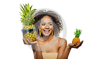 Model with pineapple in hands. African American Girl with Exotic Fruit. Cheerful woman with a smile relaxing on vacation. Image