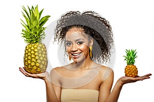 Model with pineapple in hands. African American Girl with Exotic Fruit. Cheerful woman with a smile relaxing on vacation. Image