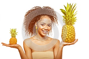 Model with pineapple in hands. African American Girl with Exotic Fruit. Cheerful woman with a smile relaxing on vacation. Image