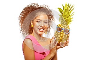 Model with pineapple in hands. African American Girl with Exotic Fruit. Cheerful woman with a smile relaxing on vacation. Image