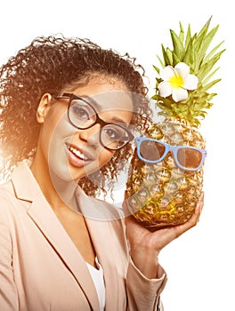 Model with pineapple in hands. African American Girl with Exotic Fruit. Cheerful woman with a smile relaxing on vacation. Image