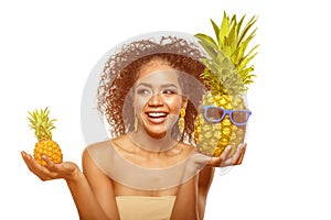 Model with pineapple in hands. African American Girl with Exotic Fruit. Cheerful woman with a smile relaxing on vacation. Image