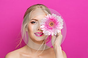 Model with Pink Lipstick. Young Woman with Summer Lips Makeup. Fashion Girl cover Eyes with Flower over Purple Studio Background