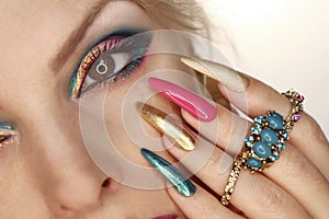A model with pink turquoise makeup and nail design.