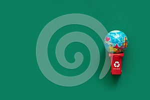 A model of planet Earth was thrown into the trash can along with empty bottles and glasses. The concept of environmental pollution