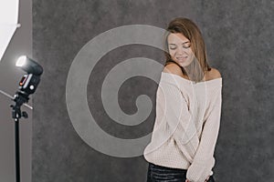 The model poses for a photo shoot. Photographing for a girl in the studio.