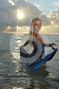 Model posing in beach dress at early morning sunrise