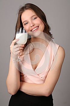 Model posing with a bocal of milk. Close up. Gray background