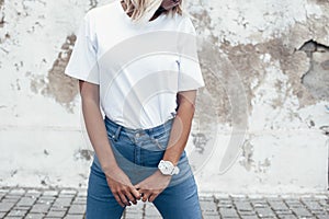 Model posing in plain tshirt against street wall